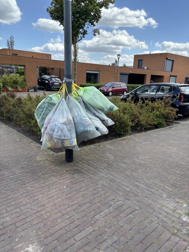 Afvalzakken met PMD aan een paal
