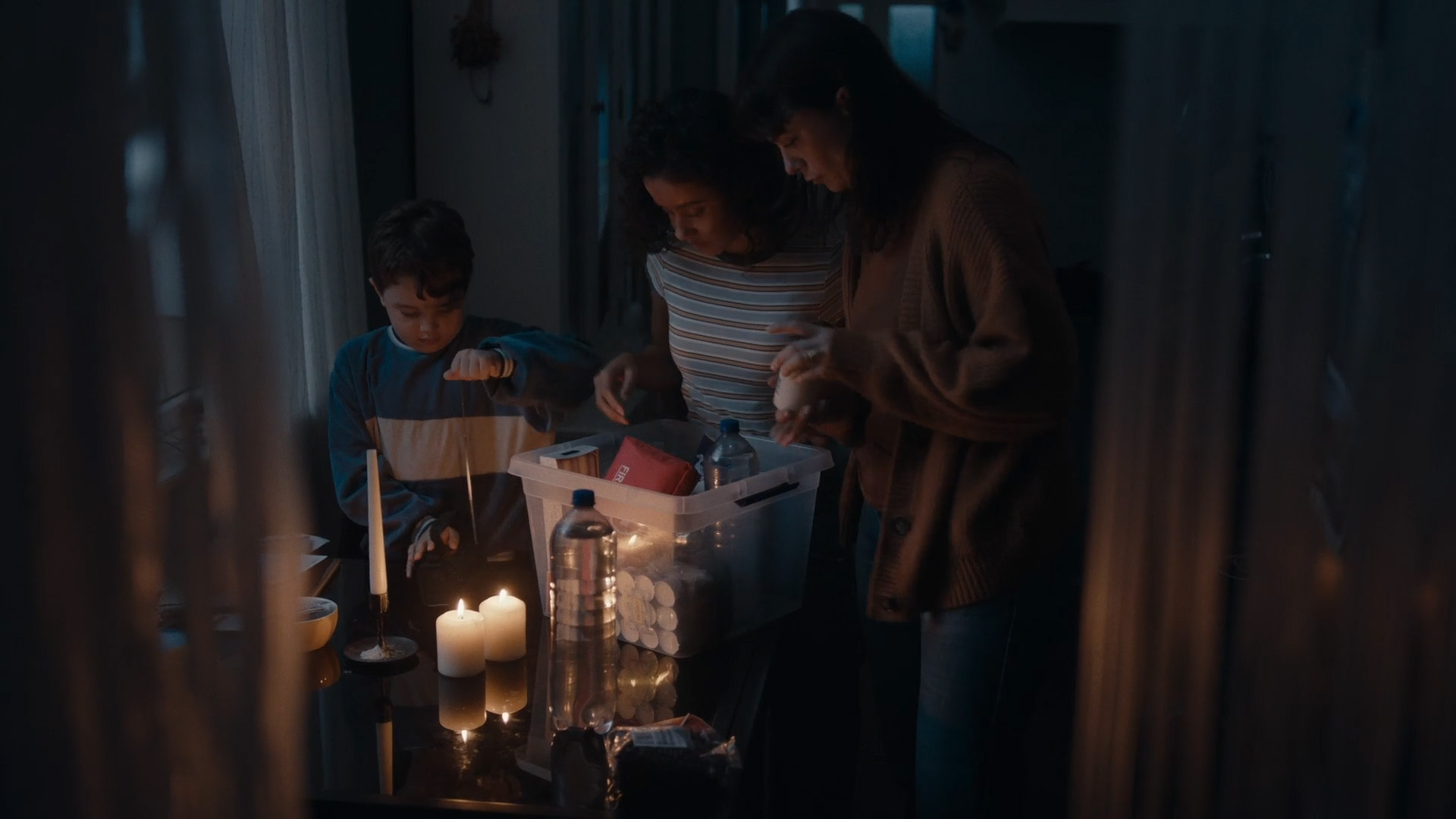 gezin met hun noodpakket met water, lucifers, een radio